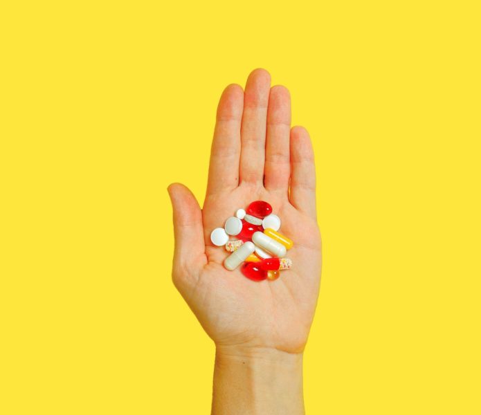 person with bunch medication pills on hand